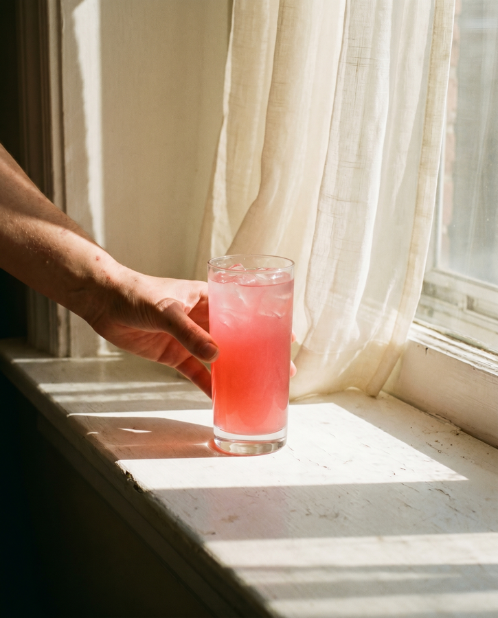 A glass of Recuperol catching the light on a windowsill